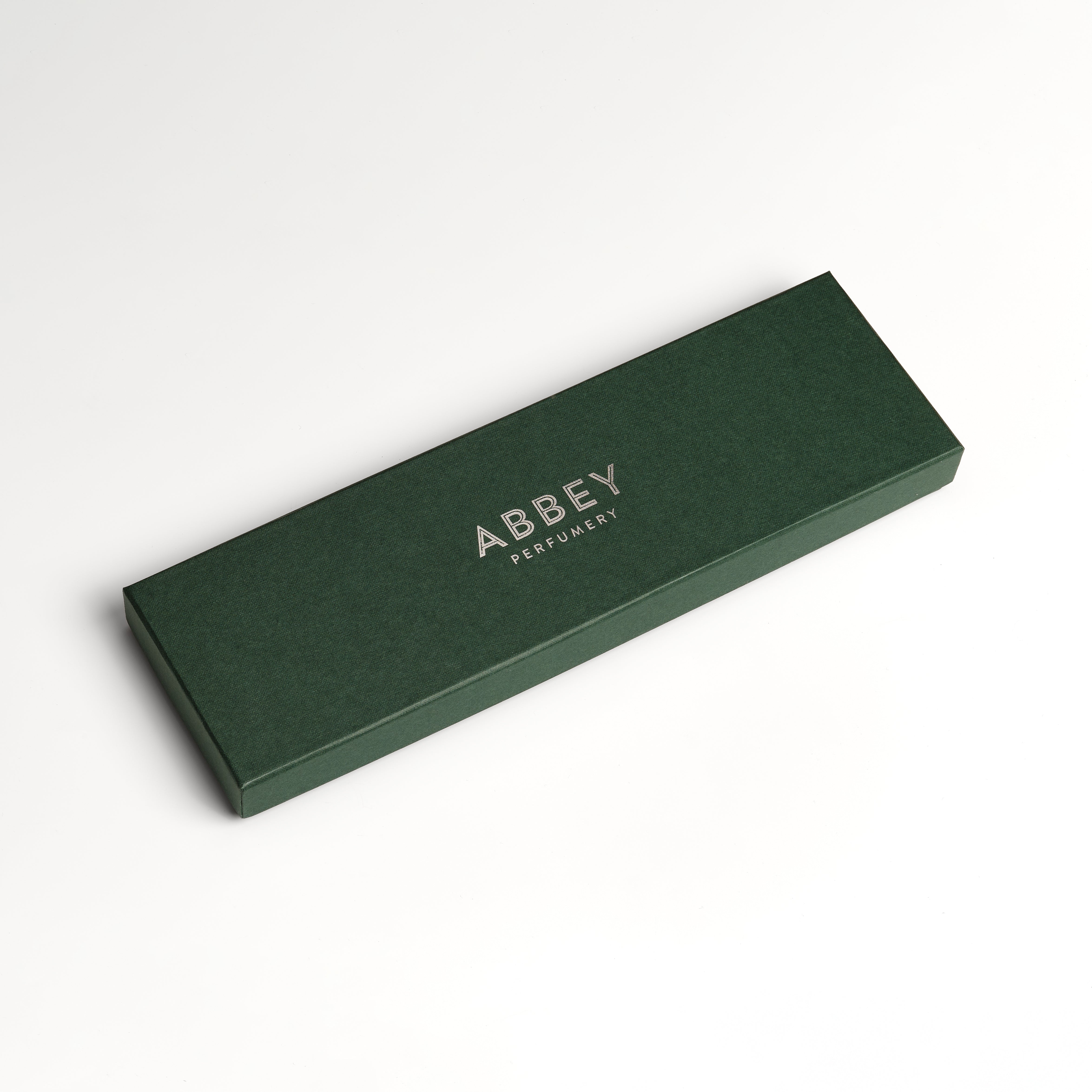 A foil blocked Abbey Perfumery green gift box on a white background